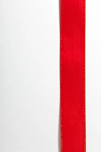 Fita vermelha brilhante no fundo branco com espaço de cópia . — Fotografia de Stock