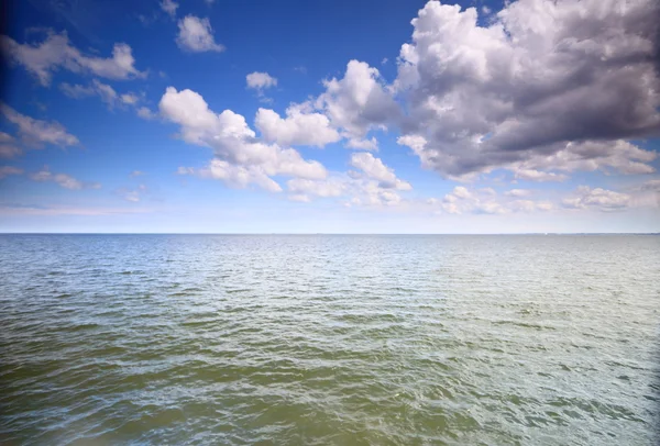 Ciel bleu nuageux au-dessus d'une surface de la mer — Photo