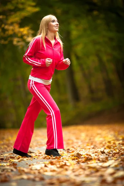 Chica rubia joven mujer corriendo corriendo en otoño otoño bosque parque — Foto de Stock
