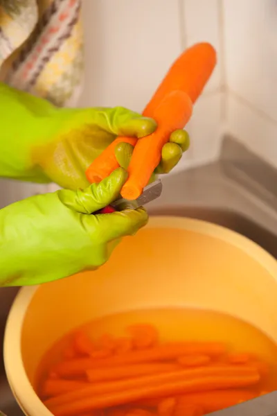 Las manos de mujer cortando zanahorias en la cocina. Nutrición saludable — Foto de Stock