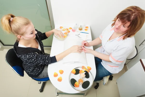 Schoonheidsspecialiste schoonmaken nagelriemen handen vrouwelijke client. Beauty salon. — Stockfoto