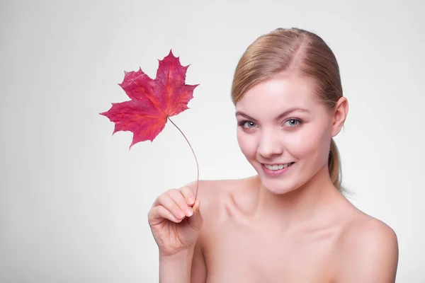 Skin care. Portrait of young woman girl with red maple leaf. — Stock Photo, Image