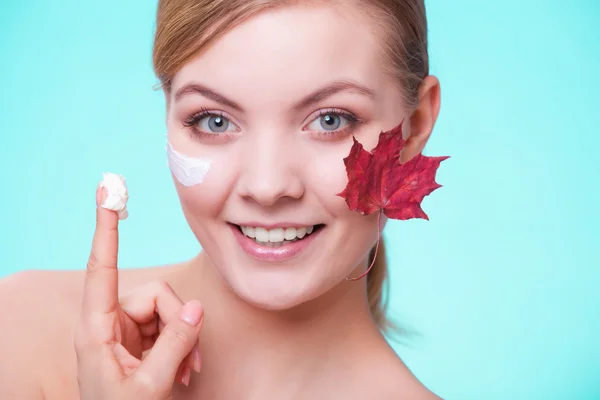 Cuidado de la piel. Cara de chica joven con hoja de arce rojo. —  Fotos de Stock