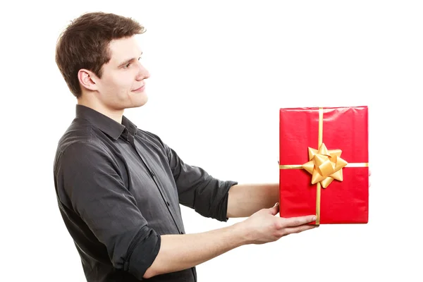 Holiday. Man giving red gift box with golden ribbon — Stock Photo, Image