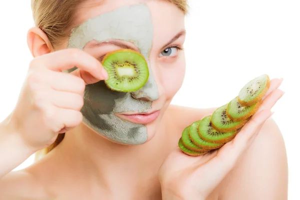 Femme en masque d'argile sur le visage couvrant l'oeil avec kiwi — Photo