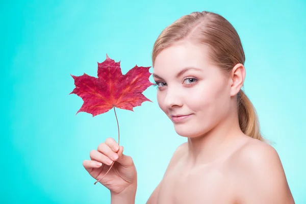 Péče o pleť. Portrét mladé ženy dívka s červeným javorovým listem. — Stock fotografie