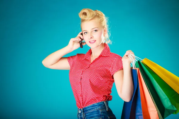 Pinup-Mädchen mit Einkaufstüten telefoniert — Stockfoto