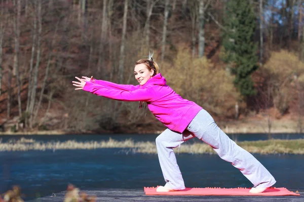 Mujer adolescente en chándal haciendo ejercicio en el muelle al aire libre —  Fotos de Stock