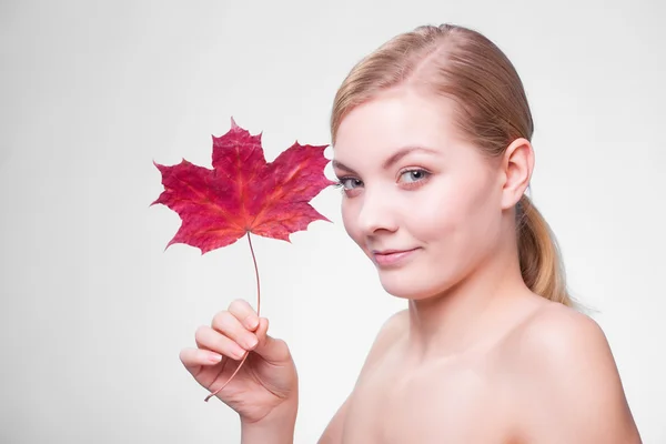 Cuidado de la piel. Retrato de chica joven con hoja de arce rojo. —  Fotos de Stock