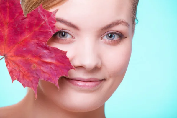 Cilt bakımı. Kırmızı akçaağaç yaprağı olan genç bir kızın portresi.. — Stok fotoğraf