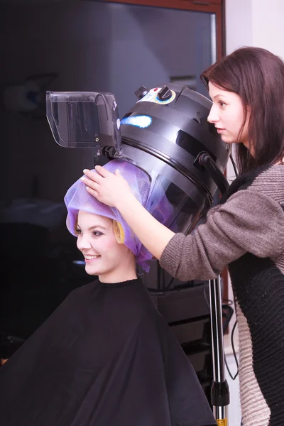 Mooi blond meisje haar krulspelden rollers kapper schoonheid salon — Stockfoto