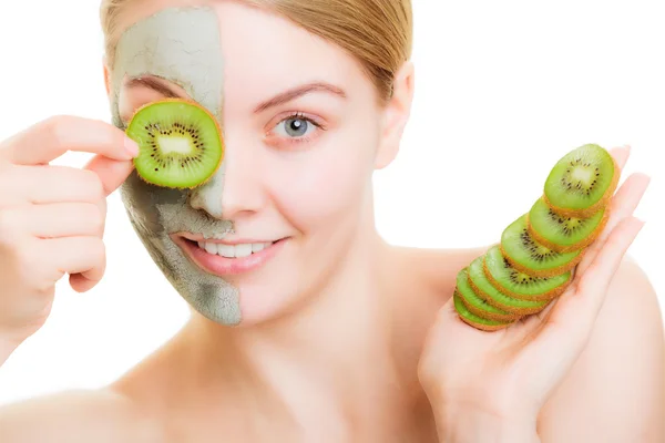 Femme en masque d'argile sur le visage couvrant l'oeil avec kiwi — Photo