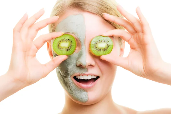 Cura della pelle. Donna in maschera di argilla con kiwi sul viso — Foto Stock