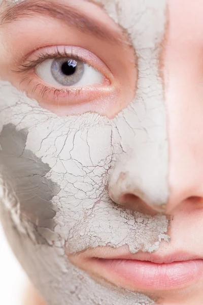 Huidverzorging. Vrouw die een kleimasker op haar gezicht aanbrengt. Kuuroord. — Stockfoto
