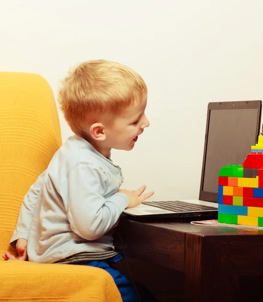 Feliz infância. Menino criança brincando no laptop. Em casa . — Fotografia de Stock