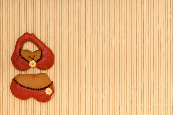 Kırmızı bikini iç çamaşırı şekli zencefilli kek kurabiye bambu hasır üzerinde — Stok fotoğraf