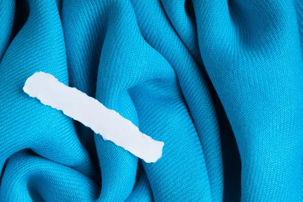 Lege afval van papier op blauw doek golvende plooien textiel achtergrond — Stockfoto