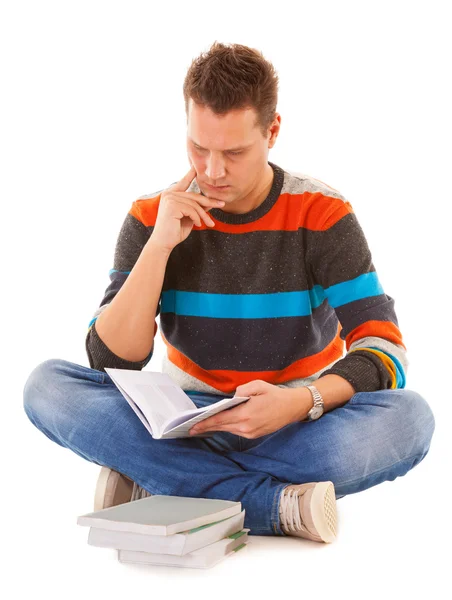 Hombre estudiante universitario sentado y leyendo libro estudiando para el examen —  Fotos de Stock