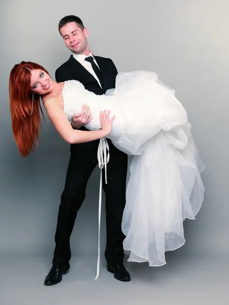 Feliz casal noivo noiva no fundo cinza — Fotografia de Stock