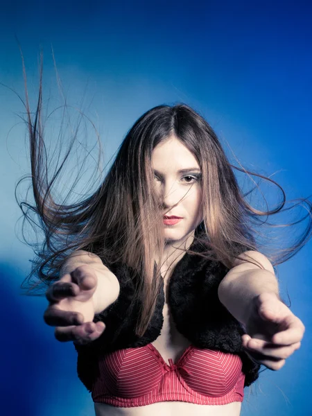 Chica de moda con el pelo largo saltando en chaleco de piel y sujetador rojo . — Foto de Stock