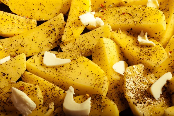 Patatas peladas crudas con especias y mantequilla como fondo alimentario —  Fotos de Stock