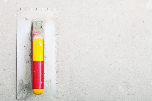 Building worktool dirty trowel on rough concrete surface — Stock Photo, Image