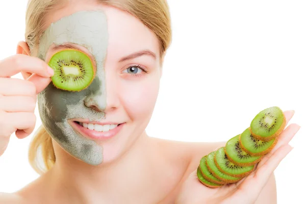 Woman in clay mask on face covering eye with kiwi — Stock Photo, Image