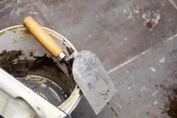 Espátula suja e balde no local de construção. Renovação em casa — Fotografia de Stock