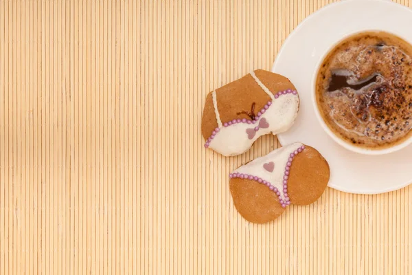 Copa de café bikini ropa interior galleta de pan de jengibre pastel en estera de bambú — Foto de Stock