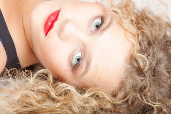 Portrait beautiful blond girl with  make up lying on floor studio shot — Stock Photo, Image