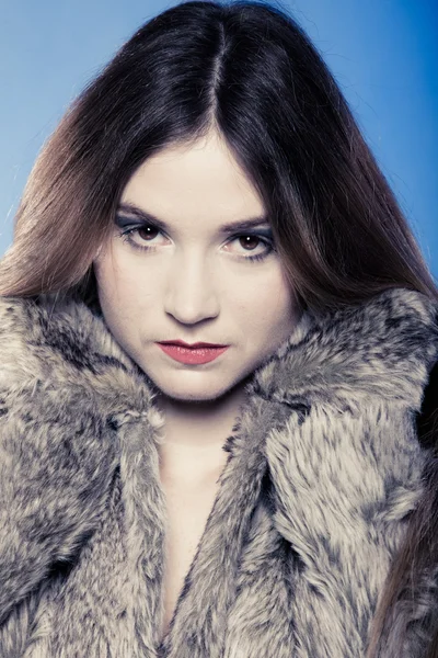 Portrait of girl with long hair. Young woman in fur coat on blue. — Stock Photo, Image