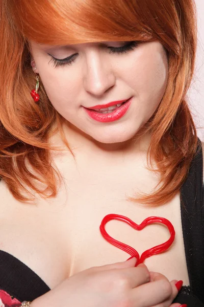 Щаслива дівчина з рудим волоссям з символом серця любові — стокове фото