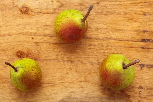 Tre pere frutta su sfondo tavolo di legno — Foto Stock