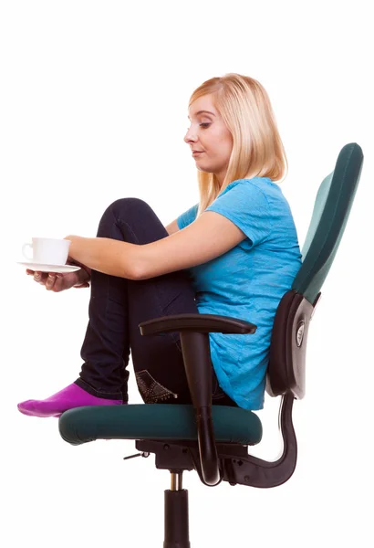 Nachdenkliches Mädchen entspannt im Stuhl hält eine Tasse Tee oder Kaffee. — Stockfoto