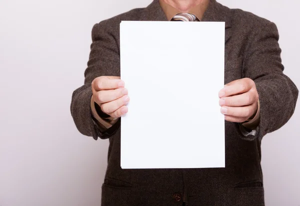 Uomo d'affari con un foglio di carta bianco. Concetto aziendale . — Foto Stock