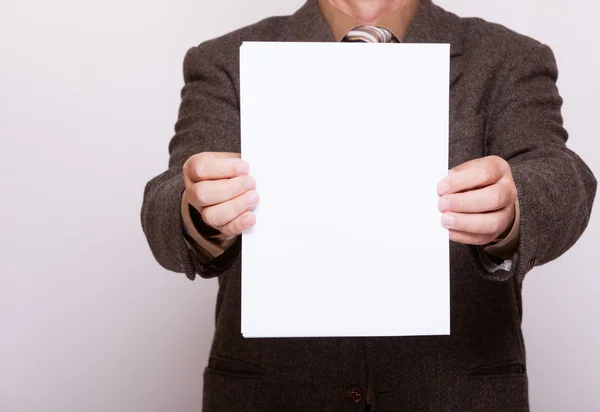 Empresário segurando folha de papel em branco. Conceito de negócio . — Fotografia de Stock