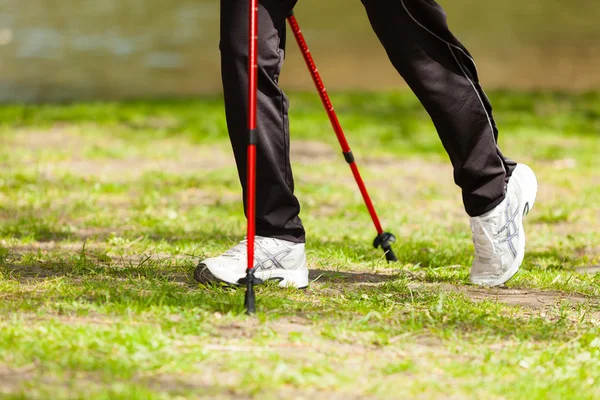 Nordic walking. Ženské nohy pěší turistika v parku. — Stock fotografie