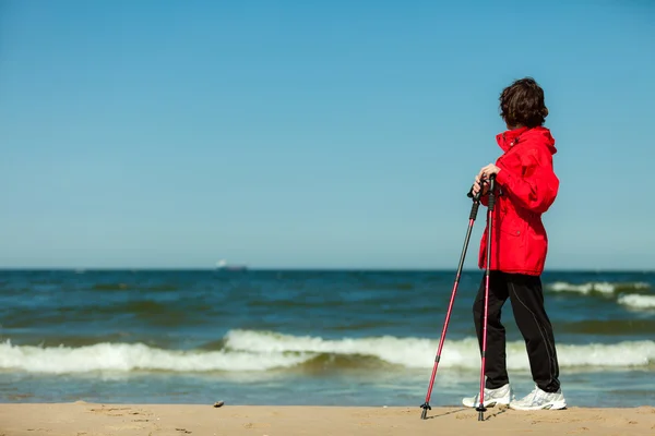 Nordic walking. Woman hiking on the beach. — Stock Photo, Image