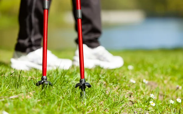 Nordic walking. Female legs hiking in the park. — Stock Photo, Image