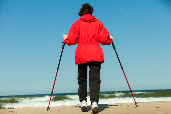 Nordic walking. Wandelende vrouw op het strand. — Stockfoto