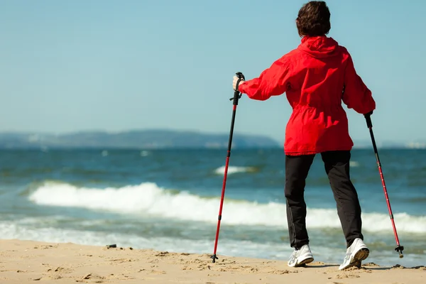 Nordic walking. Žena turistika na pláži. — Stock fotografie