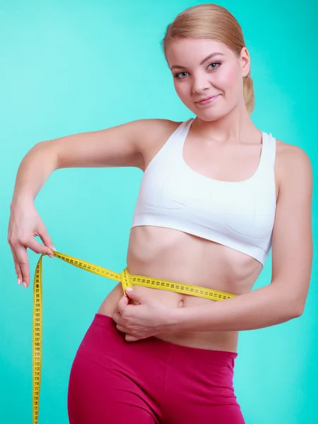 Dieta. fitness kobieta pasuje dziewczyna z środka taśmy pomiarowe jej talii — Zdjęcie stockowe