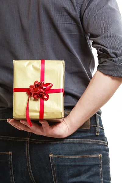 Hombre ocultando caja de regalo sorpresa detrás de nuevo — Foto de Stock