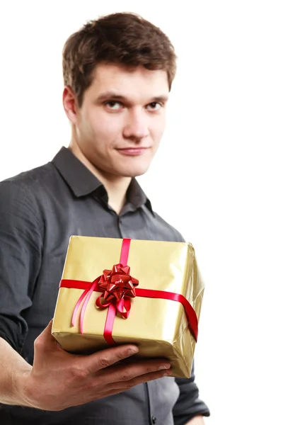 Man giving golden gift box with ribbon — Stock Photo, Image