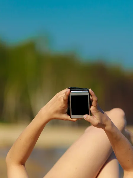 电话在海滩上晒黑的女孩 — 图库照片