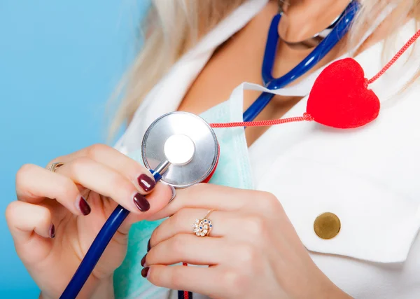 Kvinna i sjuksköterska kostym med stetoskop och rött hjärta. hälso-och sjukvård — Stockfoto