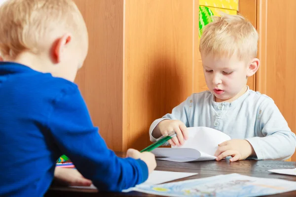 Två pojkar med penna som skriver på papper. — Stockfoto