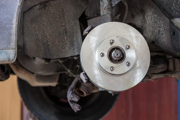 Přední kotoučová brzda na autě v procesu poškozené výměny pneumatik. — Stock fotografie