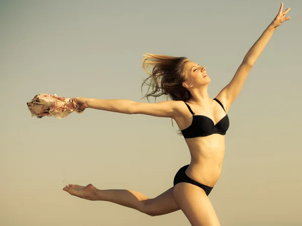 Meisje in bikini loopt op het strand — Stockfoto