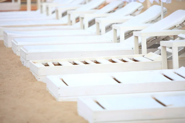 Cadeiras de piscina branca na praia de areia — Fotografia de Stock